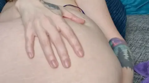 Dövme ve gözlüklü kıvrımlı beyaz kadın yatakta mastürbasyon yapıyor