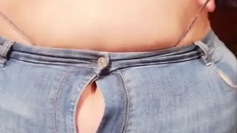 Thick brunette MILF unzips pants and exposes breasts in kitchen