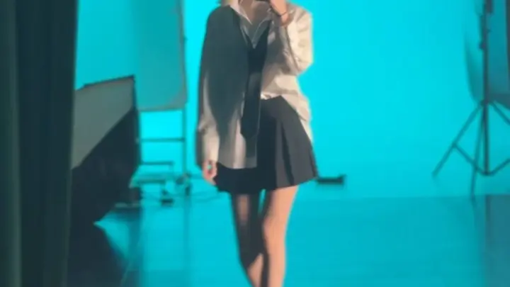 ブルーの照明の下で全裸セルフィーを撮る金髪の女の子