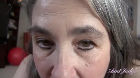 Mature brunette with big tits plays with herself on couch