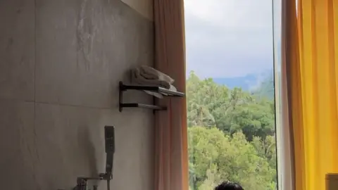 Brunette in bathtub relaxing with water dripping down her body