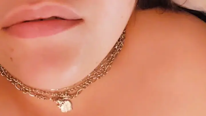 Brunette with nose piercing teases with finger on lips in close-up
