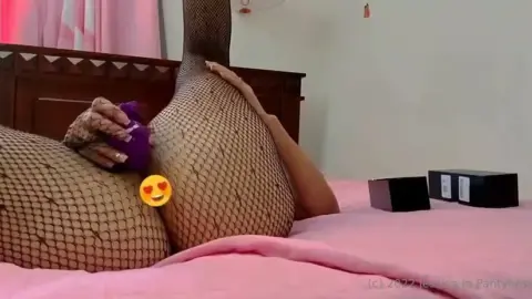 Brunette in fishnets jerks off on pink bed with toy