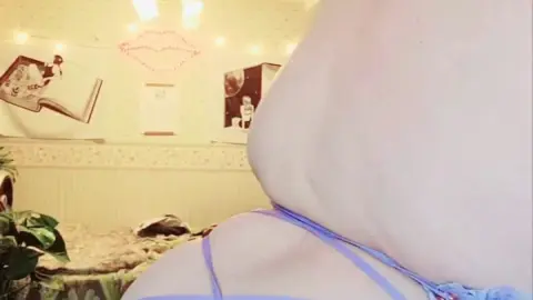 Curvy brunette MILF in blue dress shows off back tattoo and ass