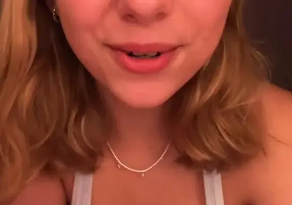 Bionda con tatuaggio ragno stuzzica décolletage in camera