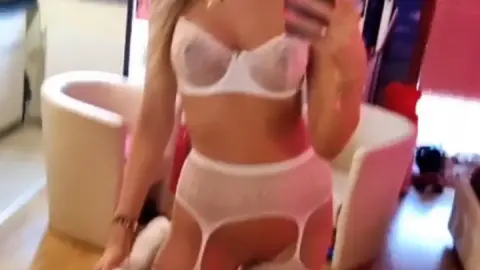 Blonde in lingerie takes selfies with stuffed animal, adjusts thigh-hi