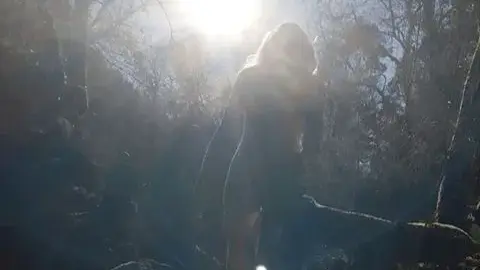 Nude brunette walking and posing in river at sunset