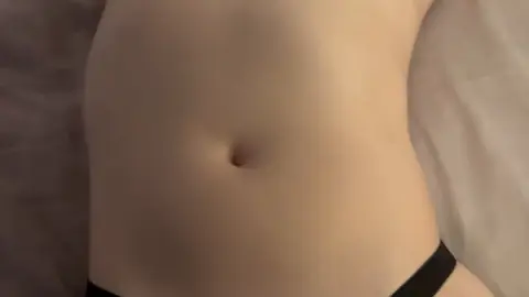 Blue-haired girl plays with dildo in bed with stuffed animals around