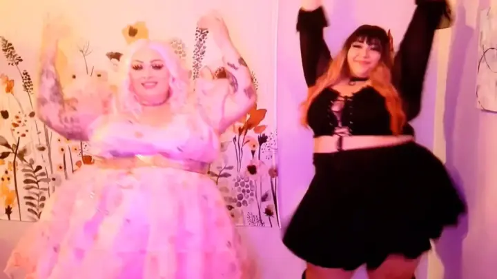 Zwei blonde und brünette Frauen tanzen vor Girl-on-Girl Action