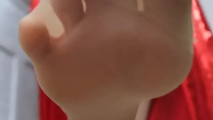 Blonde Schönheit im roten Kleid und violetten Handschuhen