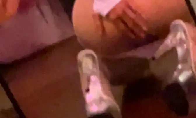 Chica blanca con cabello negro se inclina sobre la cama, mostrando su culo en el espejo