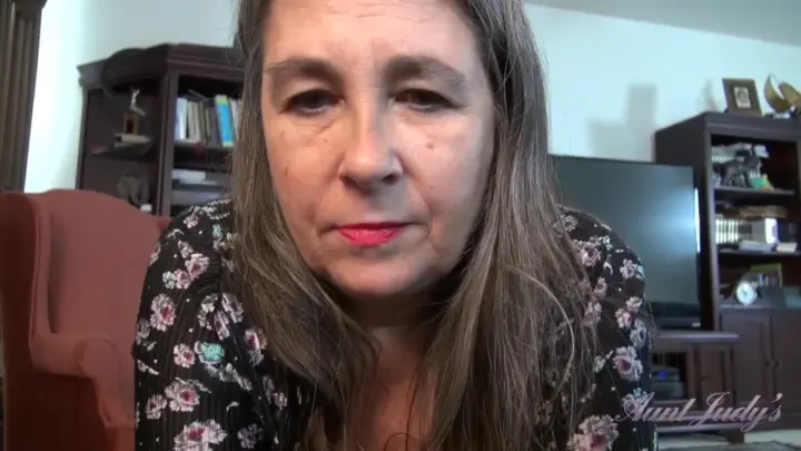 Mulher madura fala para a câmera e mostra pelos pubianos