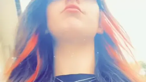 Брюнетка с пирсингом носа делает селфи на улице