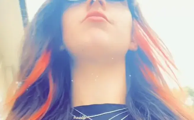 Брюнетка с пирсингом носа делает селфи на улице